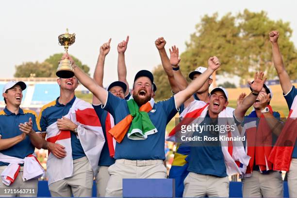 Shane Lowry of Team Europe lifts the Ryder Cup trophy following victory with 16 and a half to 11 and a half win following the Sunday singles matches...