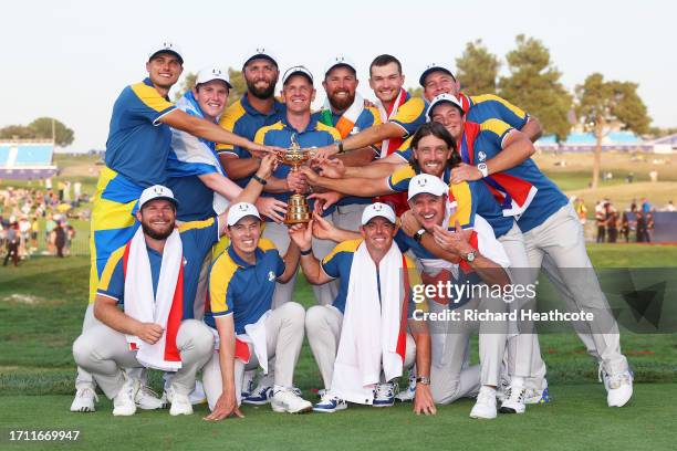 Luke Donald, Captain of Team Europe and players of Team Europe pose with the Ryder Cup trophy following victory with 16 and a half to 11 and a half...