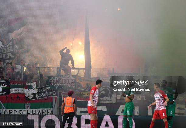 Augsburg fans light flares during the Bundesliga match between Sport-Club Freiburg and FC Augsburg at Europa-Park Stadion on October 01, 2023 in...