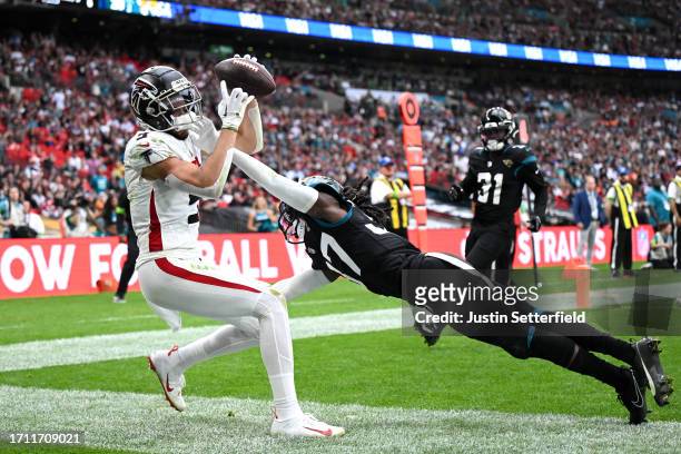 Drake London of the Atlanta Falcons catches the ball out of bounds in the endzone under pressure from Tre Herndon of the Jacksonville Jaguars in the...