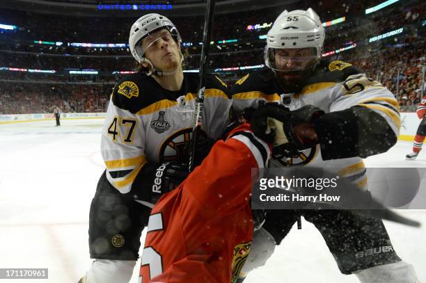 Torey Krug and Johnny Boychuk of the Boston Bruins check Andrew Shaw of the Chicago Blackhawks in Game Five of the 2013 NHL Stanley Cup Final at...