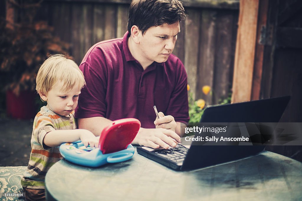 Father and son working on their laptops together