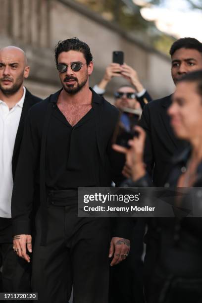 Michele Morrone is seen wearing a black jacket, with a black T-shirt and black fabric pants and black sunglasses during the Elie Saab Show Womenswear...