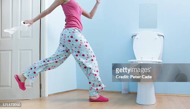 woman running to toilet in night clothes - man toilet stock-fotos und bilder