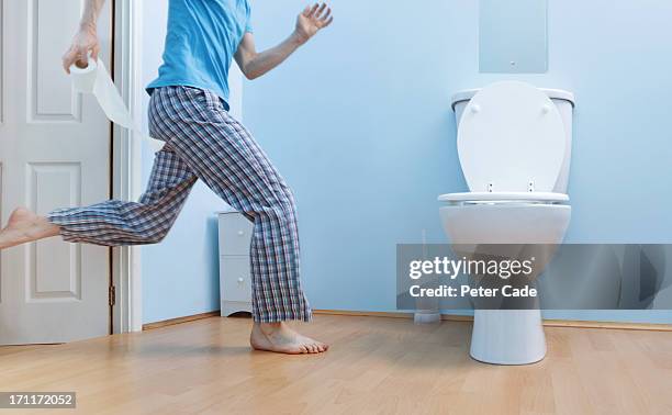 man in night clothes running to toilet - gabinetto foto e immagini stock