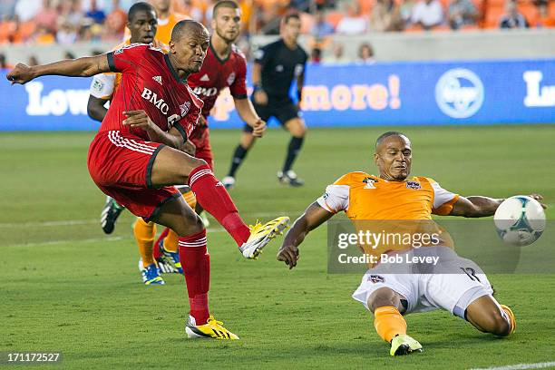 Robert Earnshaw of Toronto FC shoots past a diving Ricardo Clark of Houston Dynamo at BBVA Compass Stadium on June 22, 2013 in Houston, Texas.