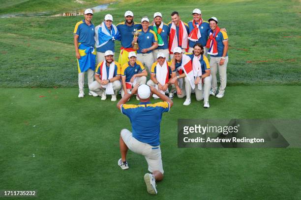 Luke Donald, Captain of Team Europe and players of Team Europe pose for a photograph with the Ryder Cup trophy following victory with 16 and a half...