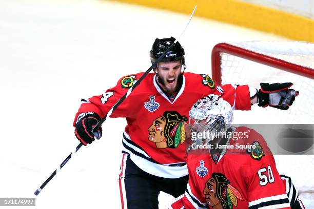 Niklas Hjalmarsson and Corey Crawford of the Chicago Blackhawks celebrate after defeating the Boston Bruins in Game Five of the 2013 NHL Stanley Cup...