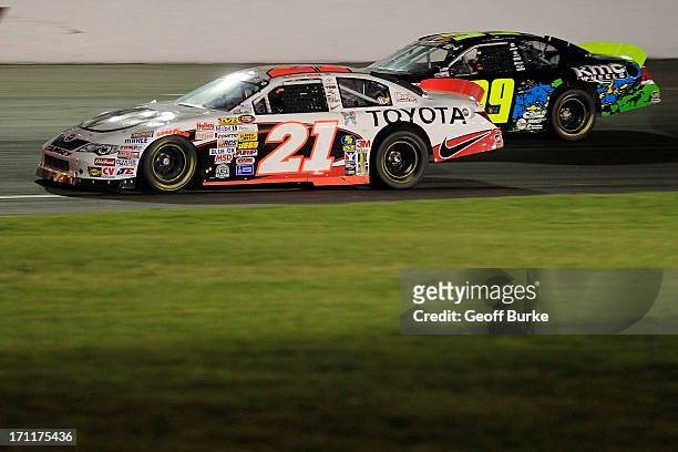 Mackena Bell, driver of the Toyota Racing Development Toyota, races Austin Dyne, driver of the KMC Wheels Chevrolet, during the NASCAR K&N Pro Series...