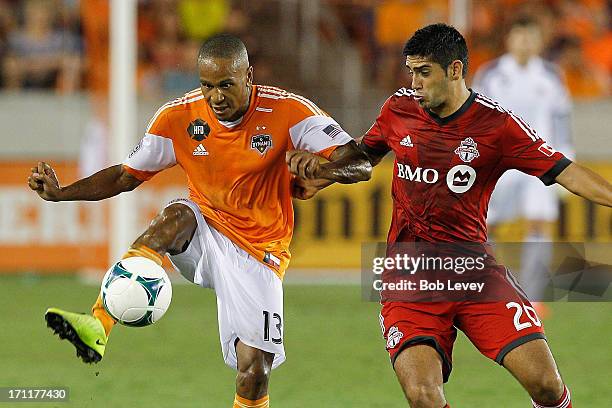 Ricardo Clark of Houston Dynamo gets control of the ball as he is defended by Matias Laba of Toronto FC at BBVA Compass Stadium on June 22, 2013 in...