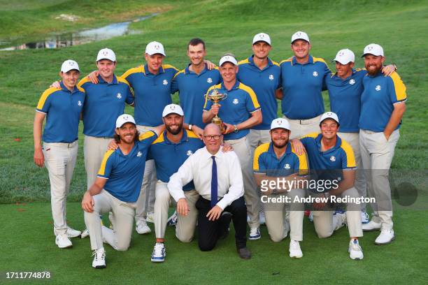 Luke Donald, Captain of Team Europe and players of Team Europe pose with the Ryder Cup trophy alongside Guy Kinnings, Deputy CEO, Ryder Cup Director...