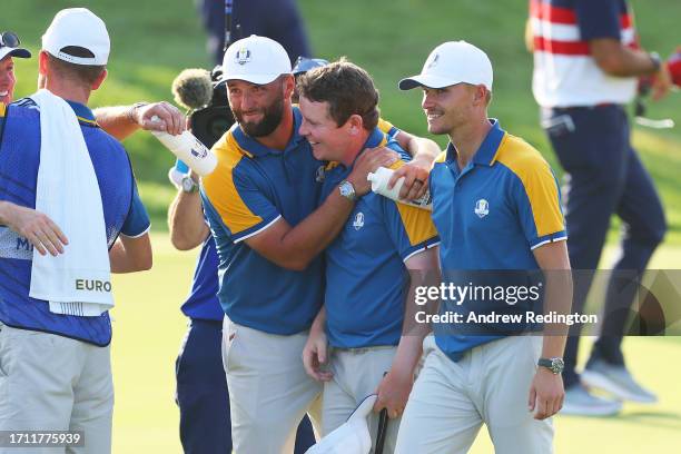 Jon Rahm, Robert MacIntyre and Nicolai Hojgaard of Team Europe celebrate on the 18th green following the Sunday singles matches of the 2023 Ryder Cup...