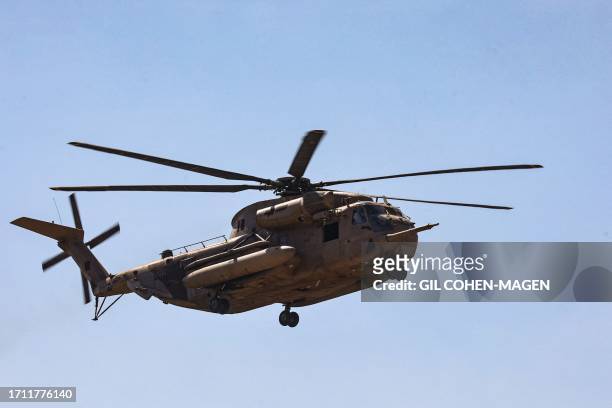 Graphic content / An Israeli army helicopter flies over an area south of Tel Aviv on its way to join a military base in southern Israel on October 7...