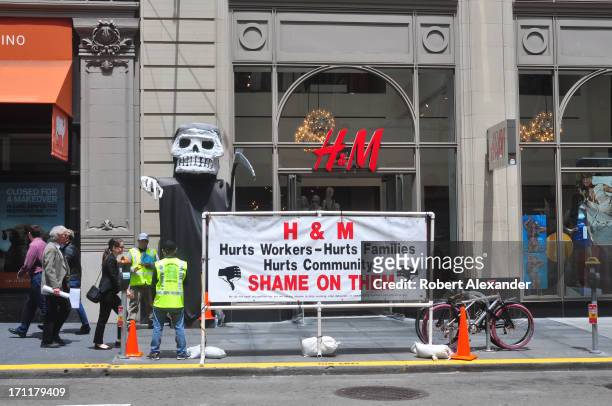 Members of a union representing carpenters hand out leaflets and post a sidewalk sign critical of Swedish fashion retailer Hennes & Mauritz in front...