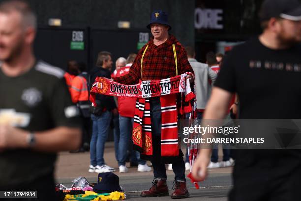 Half and half scarf salesman tries his luck outside the ground ahead of the English Premier League football match between Manchester United and...