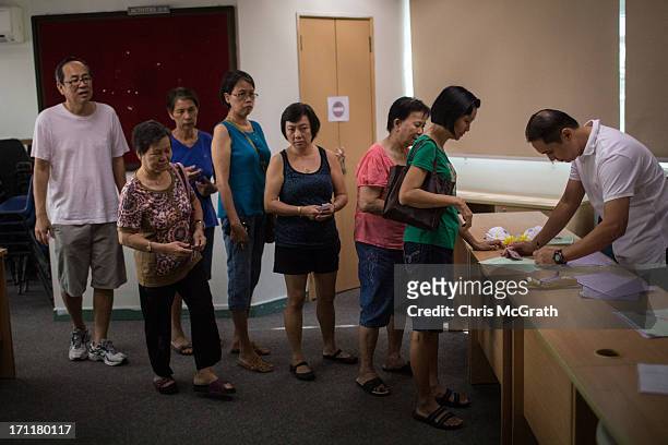 Residents queue up to receive free N95 masks at the Ang Mo Kio Community Center on June 23, 2013 in Singapore. Elderly and low income Singaporeans...