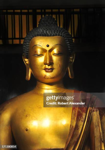 Ch'ing Dynasty gilded wood Buddha carved for a summer palace in Northern China greets shoppers as they enter the Gumps's store in San Francisco,...