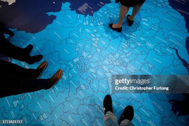Delegates walk across a map of parliamentary constituencies on the first day of the Conservative Part Conference at Manchester Central on October 01,...