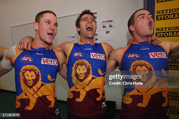 Jack Redden, Simon Black and Tom Rockcliff of the Lions sing the team song after winning the round 13 AFL match between the Brisbane Lions and the...