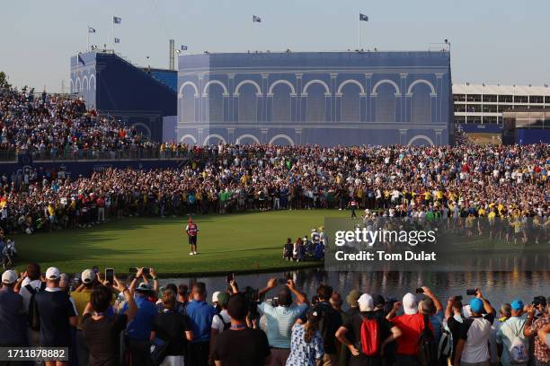 Jordan Spieth of Team United States walks across the 18th green whilst preparing to putt as fans surround the green during the Sunday singles matches...