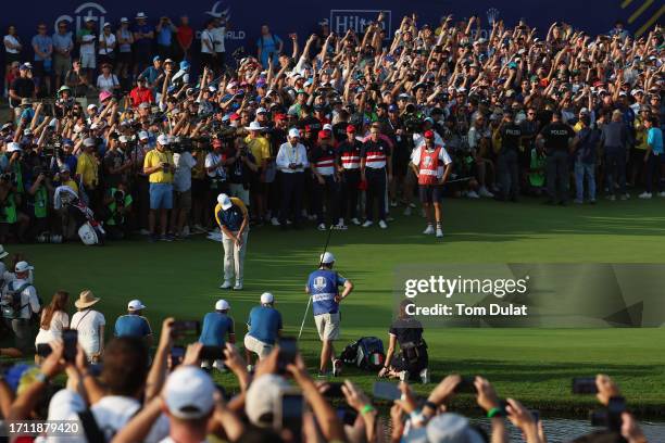 Shane Lowry of Team Europe putts on the 18th green as fans look on during the Sunday singles matches of the 2023 Ryder Cup at Marco Simone Golf Club...