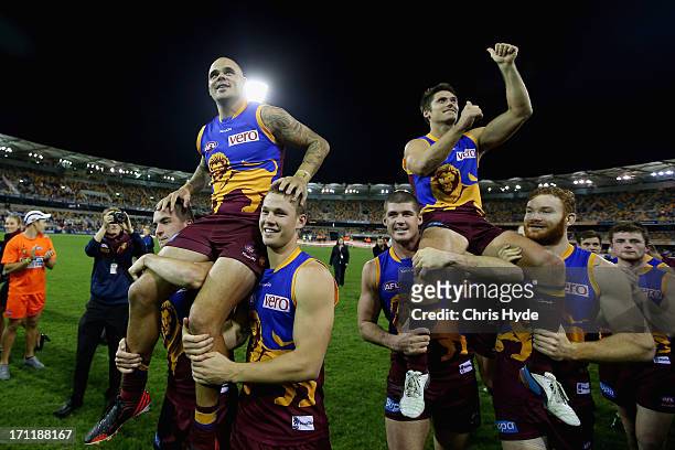 Ashley McGrath and Simon Black are chaired off after McGrath's 200th game and Black's 320th game during the round 13 AFL match between the Brisbane...