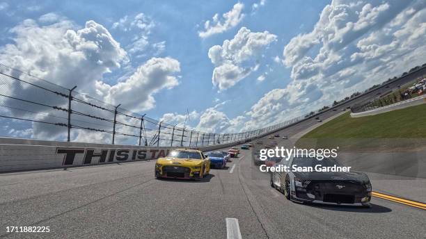 Aric Almirola, driver of the Smithfield Ford, and Joey Logano, driver of the Shell Pennzoil Ford, lead the field on a pace lap prior to the NASCAR...
