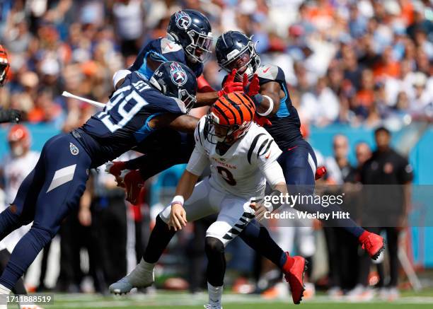 Joe Burrow of the Cincinnati Bengals is pressured by Arden Key of the Tennessee Titans during the first half at Nissan Stadium on October 01, 2023 in...