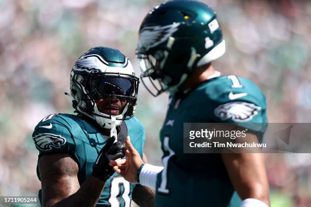 Andre Swift and Jalen Hurts of the Philadelphia Eagles celebrate a touchdown by Swift during the first quarter against the Washington Commanders at...