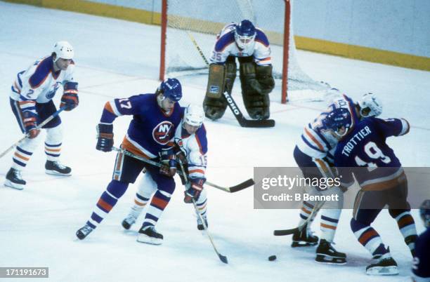 Greg Gilbert and Bryan Trottier of the New York Islanders battle with Pat Conacher and Kevin McClelland of the Edmonton Oilers for the puck during...