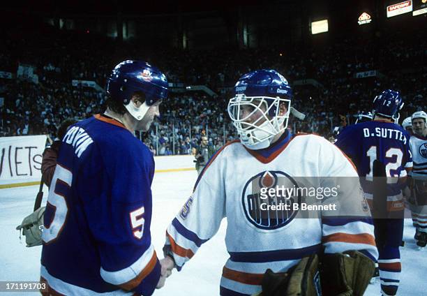 Goalie Andy Moog of the Edmonton Oilers shakes hands with Denis Potvin of the New York Islanders after Game 5 of the 1984 Stanley Cup Finals on May...