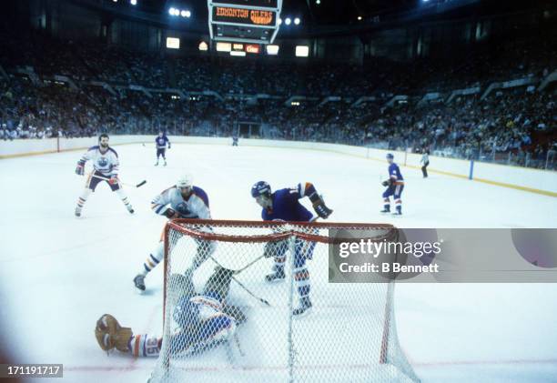 Goalie Andy Moog and Don Jackson of the Edmonton Oilers defend the net as Pat LaFontaine of the New York Islanders looks for the rebound during the...