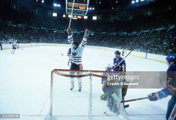 Dave Semenko of the Edmonton Oilers celebrates his goal as goalie Billy Smith and Denis Potvin of the New York Islanders look dejected during the...