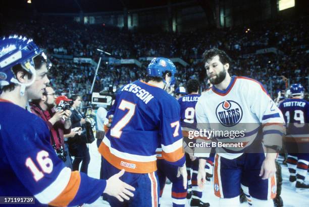 Dave Semenko of the Edmonton Oilers shakes hands with Pat LaFontaine and Stefan Persson of the New York Islanders after Game 5 of the 1984 Stanley...