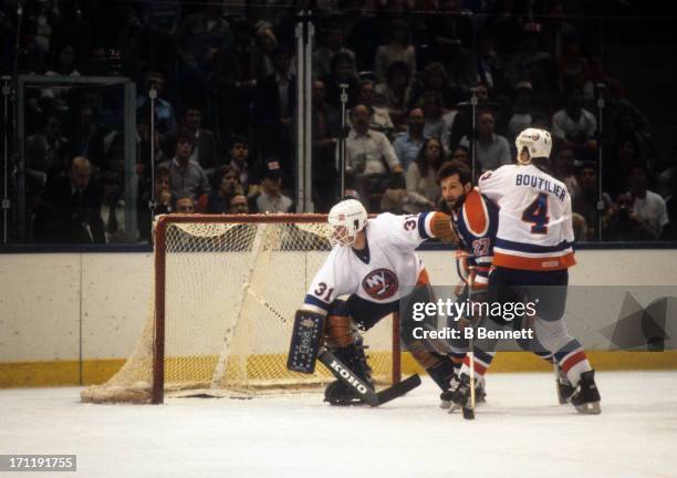 Goalie Billy Smith and Paul Boutilier of the New York Islanders defend the net against Dave Semenko of the Edmonton Oilers during the 1984 Stanley...