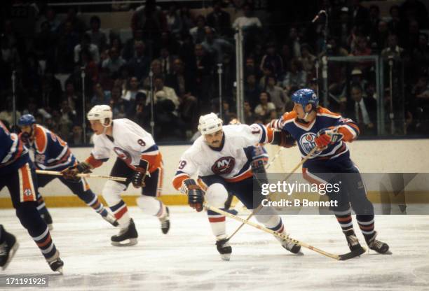 Jari Kurri of the Edmonton Oilers is defended by Bryan Trottier of the New York Islanders during the 1984 Stanley Cup Finals in May, 1984 at the...