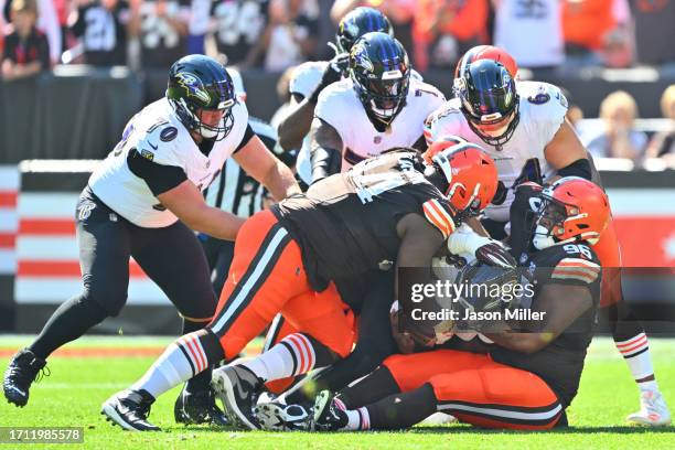 Dalvin Tomlinson of the Cleveland Browns and Jordan Elliott of the Cleveland Browns sack Lamar Jackson of the Baltimore Ravens during the first...