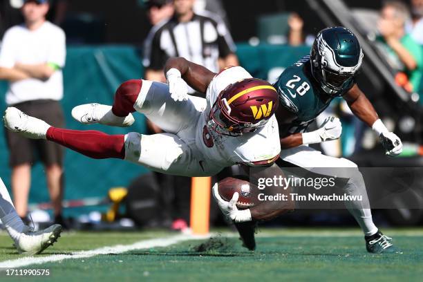 Brian Robinson Jr. #8 of the Washington Commanders carries the ball for a touchdown against the Philadelphia Eagles during the fourth quarter at...