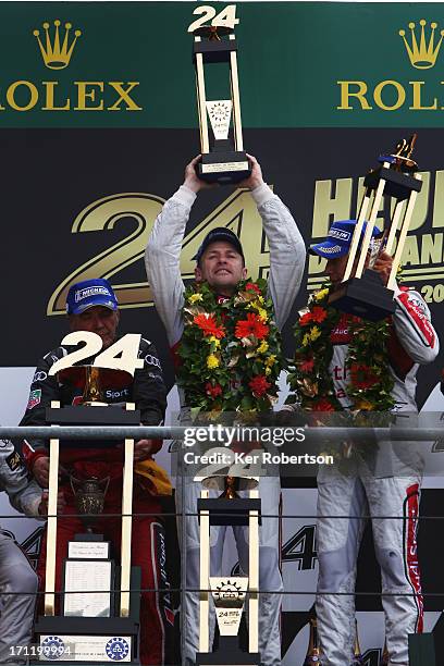 Tom Kristensen of Denmark lifts the trophy after winning the Le Mans 24 hour race with his fellow Audi Sport Team e-tron quattro co-drivers Allan...