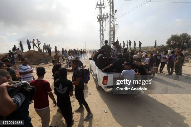 The Al-Qassam Brigades, the armed wing of the Palestinian resistance group Hamas welcomes by Palestinians as smoke rises near Israel-Gaza border in...