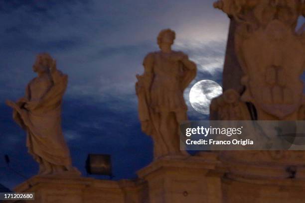 In this picture taken in the night between June 22 and June 23 the moon is framed by a sculpture of the Colonnade overlooking St. Peter's Square on...