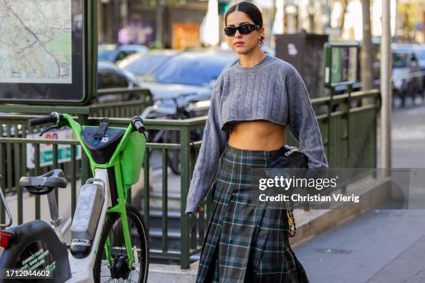 Guest wears grey cropped knit, black Chanel bag, checkered skirt outside Ottolinger during the Womenswear Spring/Summer 2024 as part of Paris Fashion...