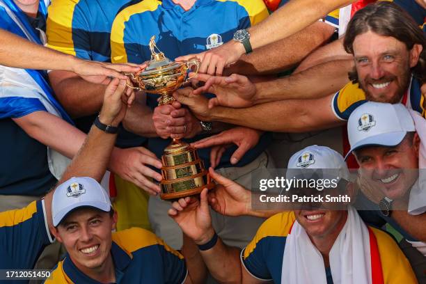 Players of Team Europe including Matt Fitzpatrick, Rory McIlroy, Justin Rose, and Tommy Fleetwood hold the Ryder Cup trophy after defeating Team...