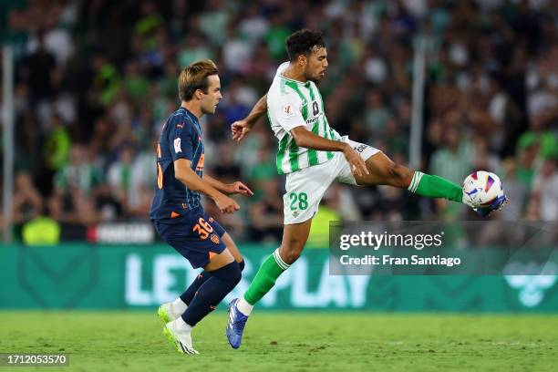 Chadi Riad of Real Betis controls the ball whilst under pressure from Mario Dominguez of Valencia during the LaLiga EA Sports match between Real...