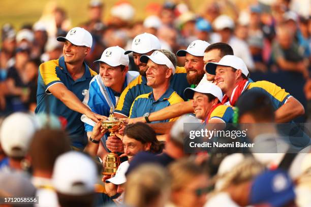 Team Europe Captain Luke Donald lifts the trophy with his team after his team win during the Sunday singles matches of the 2023 Ryder Cup at Marco...