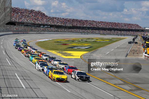Aric Almirola, driver of the Smithfield Ford, and Joey Logano, driver of the Shell Pennzoil Ford, race during the NASCAR Cup Series YellaWood 500 at...