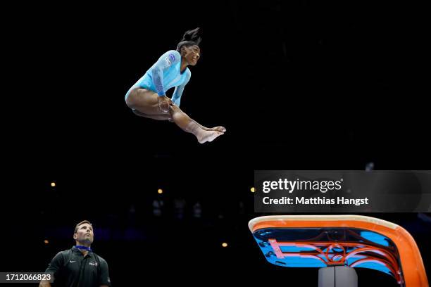 Simone Biles of Team United States performs her new jump routine 'Biles II' Yurchenko double pike vault with coach Laurent Landi on the mat for...