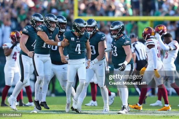 Jake Elliott of the Philadelphia Eagles celebrates his game winning overtime field goal alongside teammates against the Washington Commanders at...