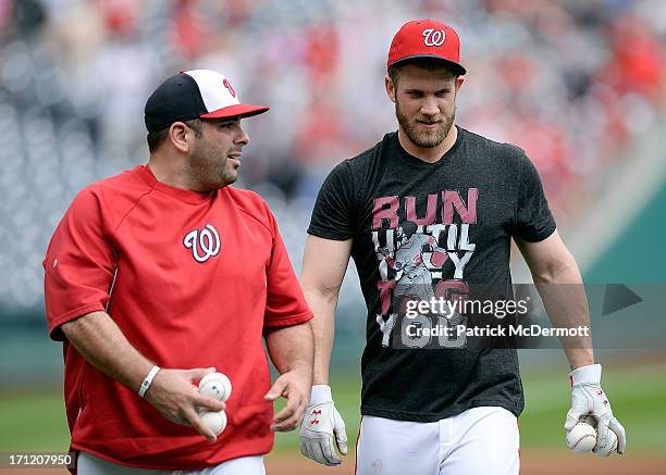Bryce Harper of the Washington Nationals talks with Nationals batting practice pitcher Ali Modami before a game between the Nationals and Colorado...