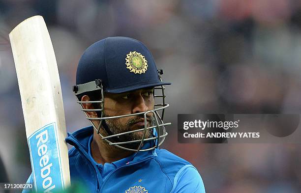 Indian captain Mahendra Sing Dhoni leaves the field after losing his wicket during the 2013 ICC Champions Trophy Final cricket match between England...